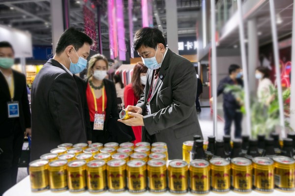 天丝集团驻中国特别代表及海南红牛总经理林明见（左）向泰国驻华大使阿塔育-习萨目（右）详细介绍红牛维生素风味饮料