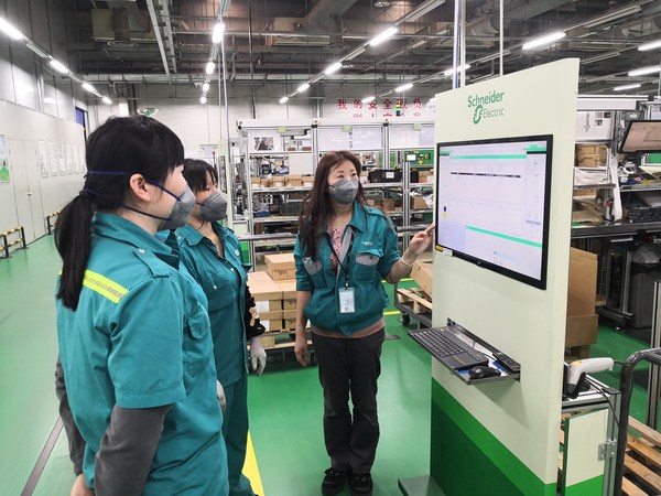 Staff members discuss work plans at French industrial group Schneider Electric's plant in Putuo district