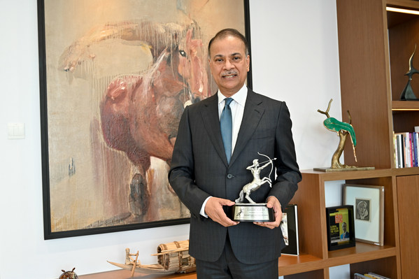 Muhammed Aziz Khan holding the pewter trophy of the ACES Awards, which he was awarded under the Outstanding Leader in Asia category for 2020.