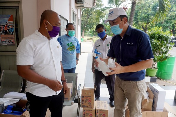 Rony Hutagalung dari Food and Beverage Division, Ecolab, menyerahkan donasi kepada Drs. Santoso, MA, Sekretaris Kecamatan Gunung Putri, di Jawa Barat, Indonesia