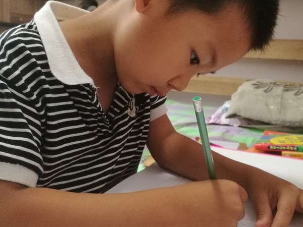 Seorang budak lelaki yang menyertai “Sumber Tenaga Masa Hadapan”, pertandingan lukisan kanak-kanak.