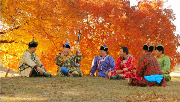 An artist (L2) performs traditional musical instrument on the Horqin Grassland, Inner Mongolia autonomous region. [Photo/China SCIO]
