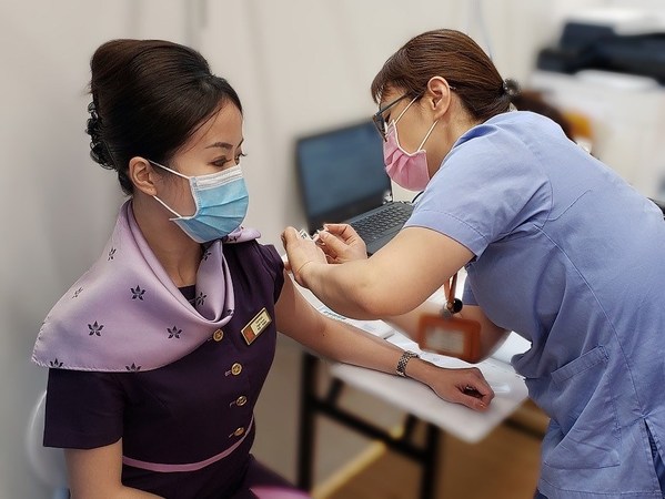 A Hong Kong Airlines crew receives her vaccine