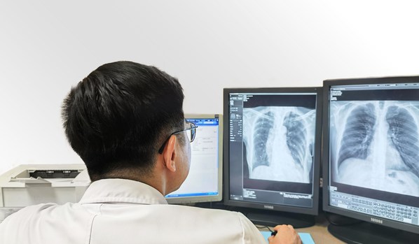 A doctor reading CXR scans using SenseCare-Chest DR Pro diagnostic software