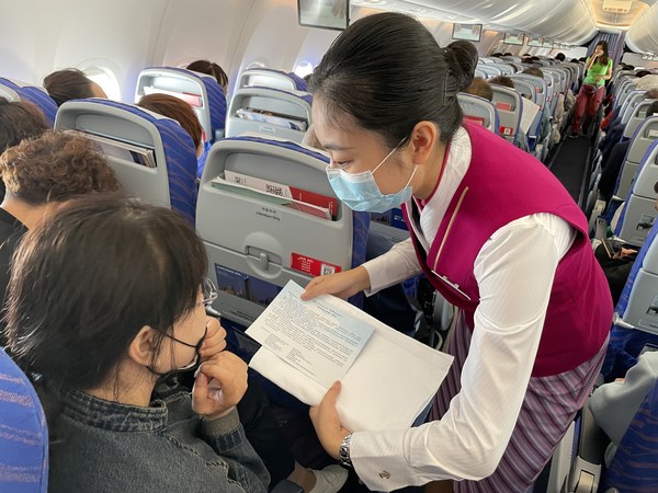 南航空乘人员向旅客发放倡导关爱自闭症群体的一封信