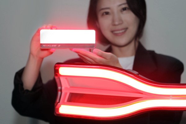 An LG Innotek employee is holding the automotive lighting module Nexlide-E. This product is 63% brighter than the previous product and produces uniform light. It can be applied to the front/rear of an automobile.