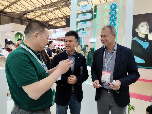 吴堃总裁（左一）向安保罗先生（右一）介绍两面针产品