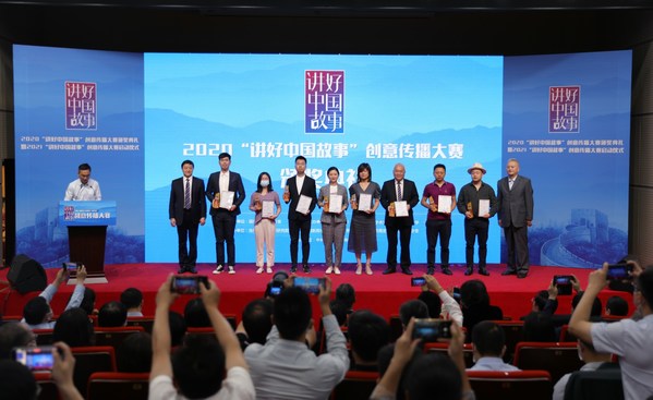 中宣部国际传播局二级巡视员张东（右一）、华中科技大学副校长许晓东（左二）为一等奖作品创作团队代表颁奖。