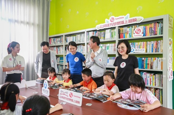 百胜中国的代表们为孩子分发儿童节礼物，并在图书角与学生们互动