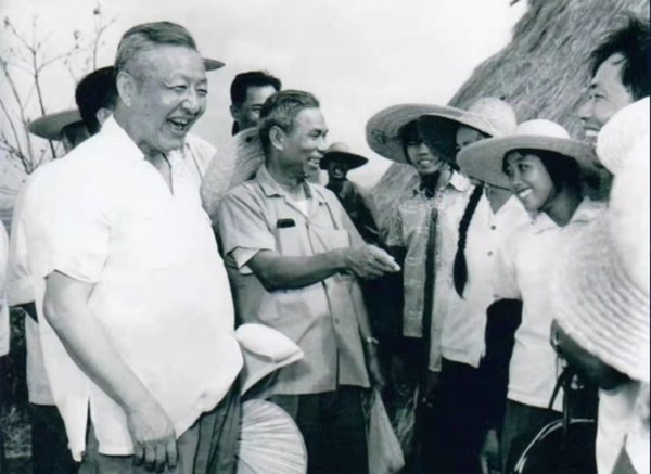 File photo of Xi Zhongxun (R) talking to people in Guangdong Province, China.