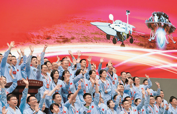 Aerospace scientists celebrate the landing of China's first probe on Mars at the Beijing Aerospace Control Center, May 15, 2021.