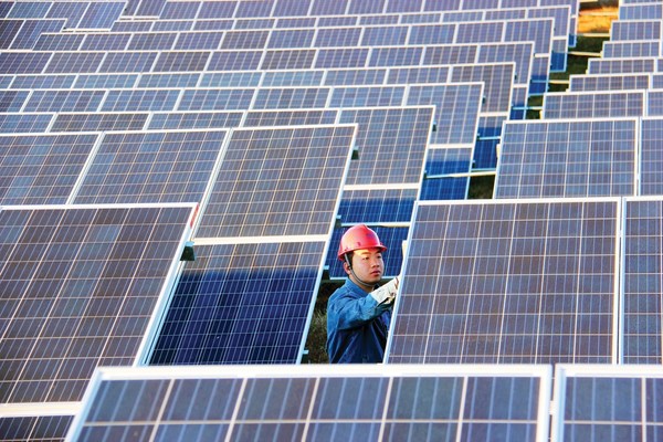 Seorang teknisi pembangkit listrik fotovoltaik Pingqing mengecek panel surya di Weining, Provinsi Guizhou, Tiongkok Barat Daya