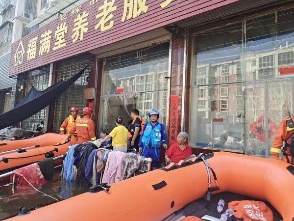 救援队员在河南卫辉市福满堂养老服务中心营救被困老人
