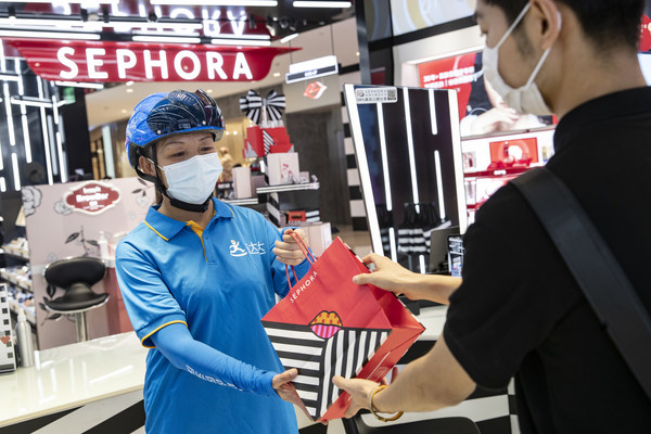 A Dada Now rider takes online orders for delivery at a Sephora store in Shanghai, China