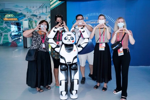 UBTECHパンダロボットとポーズするビジターグループ＝中国国際貿易促進委員会提供