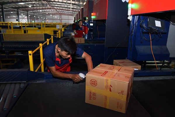 在百世越南胡志明市的转运中心，工作人员正在扫描一箱从中国寄来的纸巾