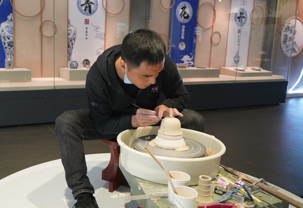 Seorang artis menunjukkan pemangkasan, salah satu kemahiran pembuatan tembikar, di Muzium tembikar biru dan putih Dinasti Yuan Gao'an, 20 November 2021.