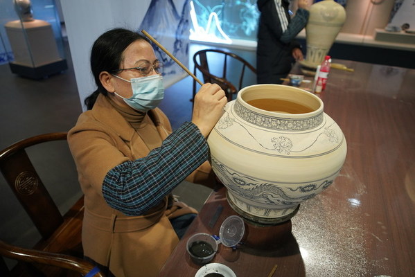 Seorang artis menunjukkan melukis, salah satu kemahiran pembuatan tembikar, di Muzium tembikar biru dan putih Dinasti Yuan Gao'an, 20 November 2021.