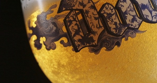 于青花杯中倾倒督威啤酒，激荡起丰富绵密的泡沫和醇厚馥郁的酒香