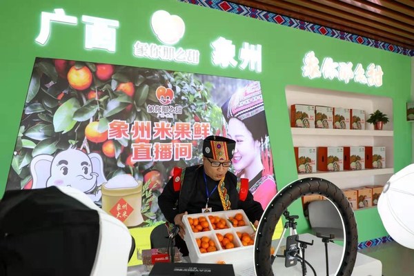 Kakitangan menjual oren gula melalui siaran langsung di Daerah Xiangzhou, Wilayah Autonomi Zhuang Guangxi, selatan China di Festival Oren Gula keenam, 17 Disember 2021.