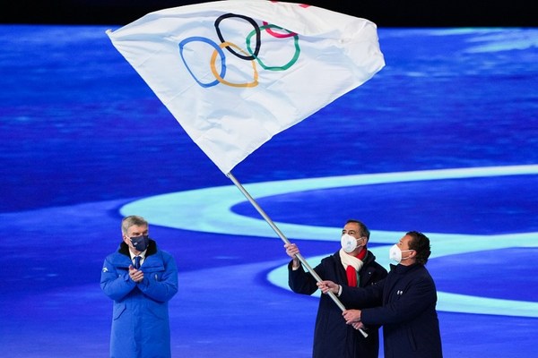 北京・国家体育場で開催された2022年冬季五輪大会閉会式で、五輪旗を掲げるジュゼッペ・サーラ（Beppe Sala）ミラノ市長（中央）とジャンピエトロ・ゲディーナ（Gianpietro Gedina）コルティナ・ダンペッツォ市長（右）。2022年2月20日／CFP