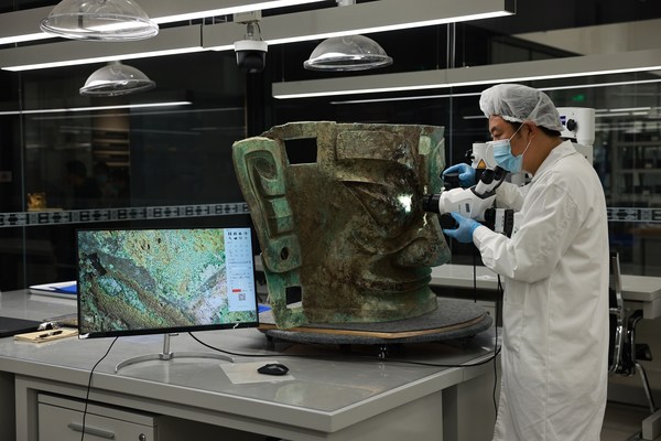 工作人员检查从三星堆遗址出土的青铜面具
