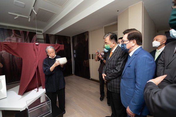 Artist Water Poon leads honored guests on a tour of 101 Bowls – An Art Exhibition featuring art by Water Poon and fashion by Romy Cheung at Sands Gallery on Wednesday.