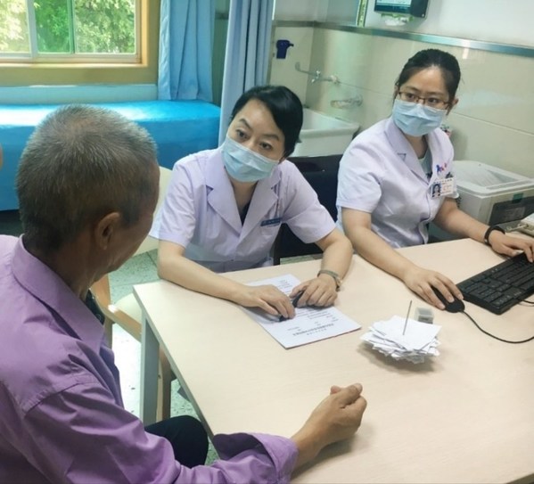 西安市中心医院消化内科主任医师庄坤正在询问患者相关病情