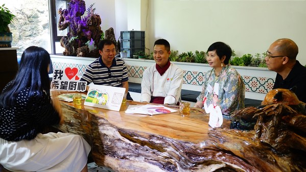李锦记中国企业事务总监赖洁珊（右二）与成都财贸职高副校长成强（左二）探访创业的希望厨师刘兴坡（中）并进行交谈