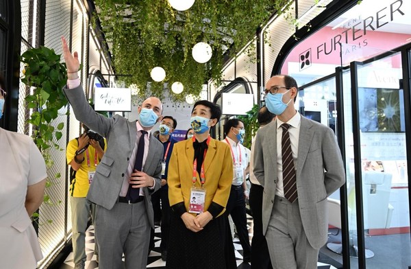 A French exhibitor shows guests around the French pavilion. (Photo/Wang Kai)