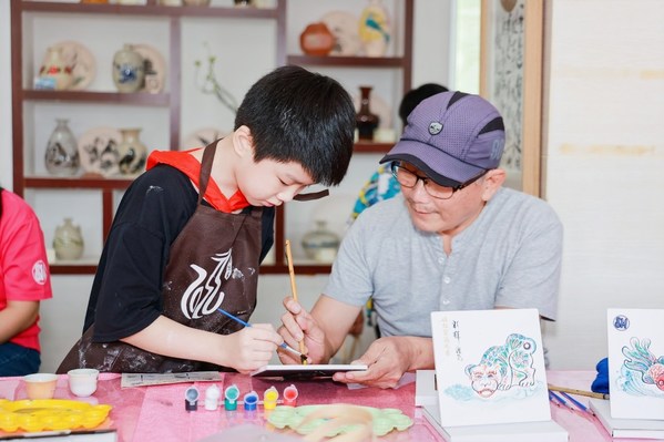 陶艺传承人指导小朋友陶瓷彩绘