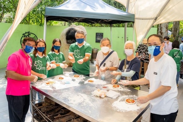 在香港，恒隆地产行政总裁卢韦柏先生（左四）联同恒隆义工，陪同认知障碍症长者及其照顾者一同参与五感体验，包括制作土窑薄饼