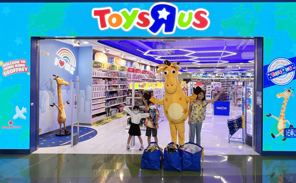 The photo contest winning family and local children's ambassador with Geoffrey in front of the toys"R"Us MegaBox store in Hong Kong.