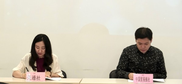 美通社媒体业务负责人赵莎（左）与中国贸易报合作发展部主任王晓龙（右）进行战略签约