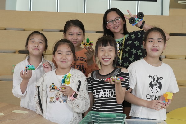女孩们参与机器人拼搭挑战活动，发挥想象力和创造力构想未来的机器人