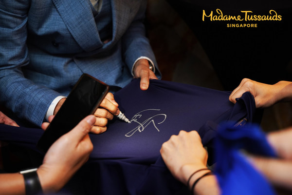 Former world no.1 badminton player, Lee Chong Wei signing his autograph for his fans (Photo: Madame Tussauds Singapore)