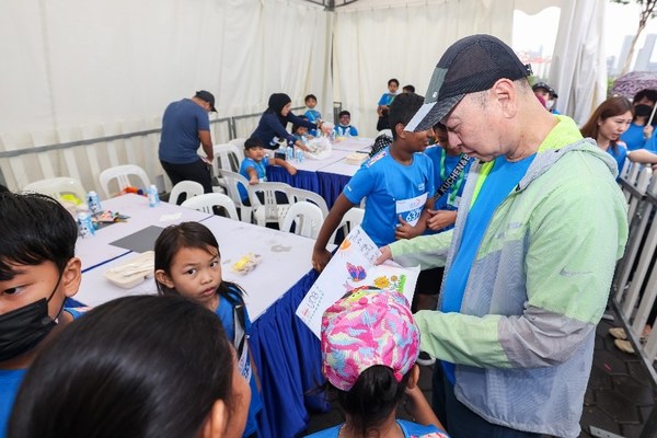 Mr Wee interacting with children from local beneficiaries at the carnival booths.
