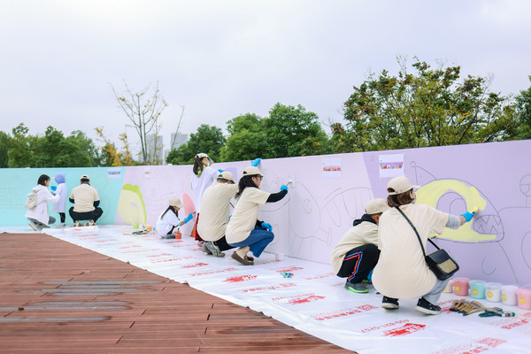 志愿者们在上海前滩鳗鲡嘴滨江绿地参与「为爱上色」ART+围墙公益彩绘活动