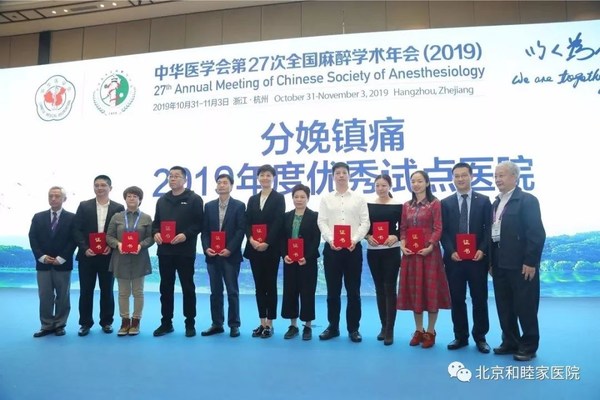 刘薇院长（时任北京和睦家医院麻醉科主任）与2019年优秀试点医院代表共同领取荣誉证书