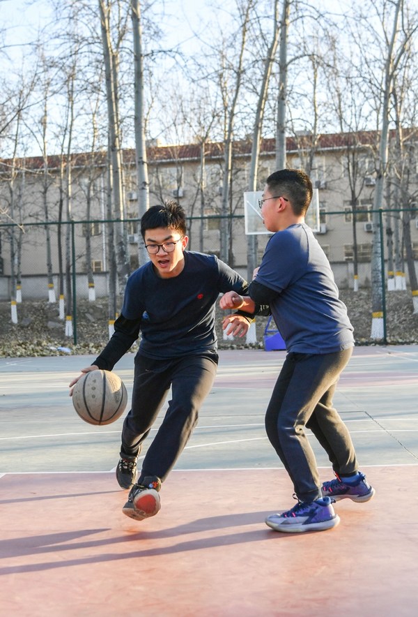 Teenagers take to an outdoor court for a game of basketball in Beijing on December 3 (WEI YAO)