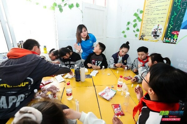 拜耳员工志愿者在“拜耳科学小课堂”上带领孩子们进行小实验