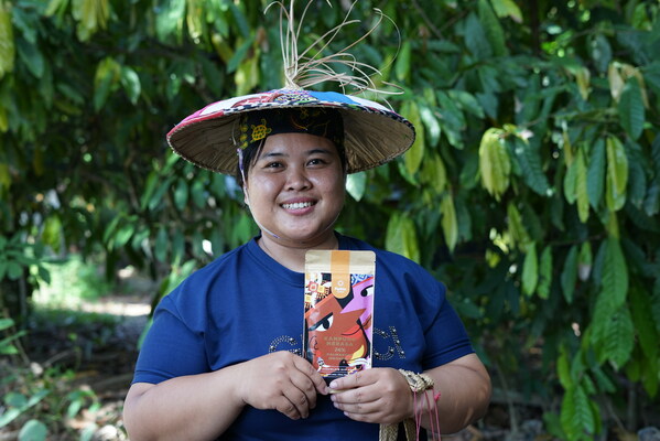 Indonesian cocoa farmer in Kampung Merasa, Berau Regency, East Kalimantan, posing with a premium chocolate product made with local cocoa beans. Courtesy: Pipiltin Cocoa.