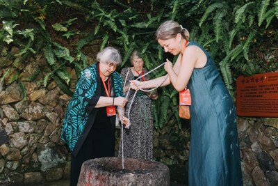 Elyn MacInnis and her daughter use a bucket to draw water from a century-old well in Kuliang. (Photo by Weng Rongfei)