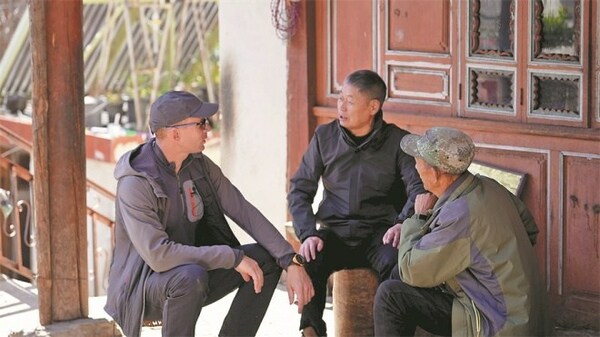 Long and Yu teach Benichou about the monkeys in Xiangguqing. [Photo / China Daily]