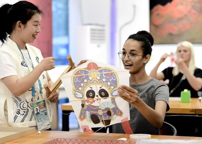 A foreign athlete learns how to make a kite at the Interactive Experience Centre of the Chengdu FISU Games Village.