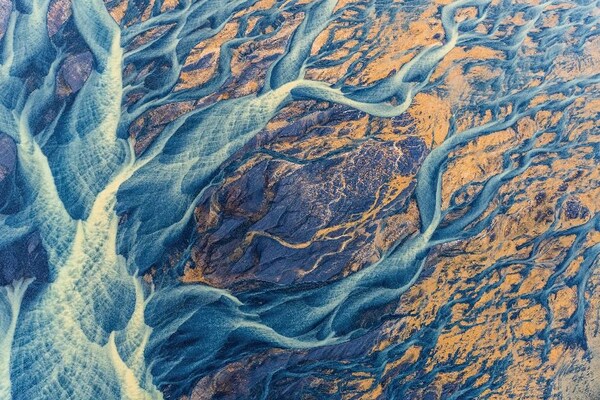 FIRST PLACE: WATER Brightly colored sediment paints the Icelandic landscape as at flows towards the ocean. The glacial river, Þjórsá, is the longest river in Iceland. © Kristin Wright/ 2022 TNC Photo Contest