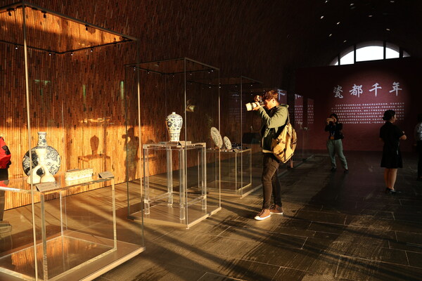 A foreign journalist takes pictures of a collection of relics exhibited at the Imperial Kiln Museum in Jingdezhen, Jiangxi province. Li Jin / China Daily