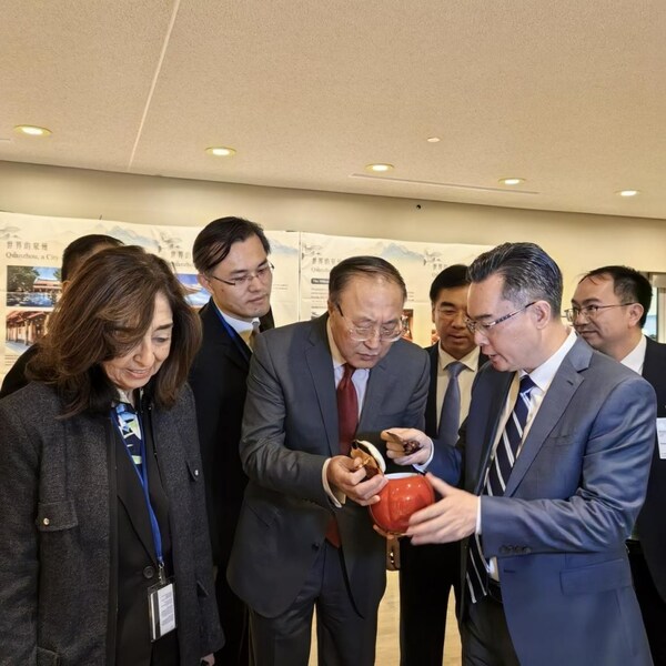 Chinese UN ambassador Zhang Jun (C), learns about Bama tea products introduced by Bama Tea chairman Wang Wenli (2nd R) at UN headquarters.