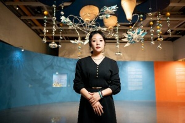 Artist Ms. Sou Leng Fong at GalaxyArt introducing her work "Blooming" which hangs from the ceiling like a chandelier.