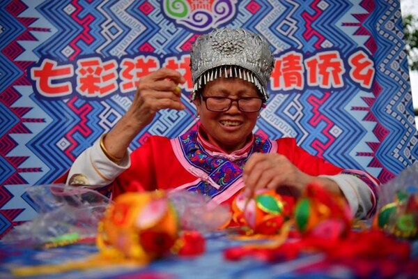 4月13日，江西省宜春市上高县敖山镇洋林归侨少数民族聚居村的村民在制作特色香囊。(时雨 摄)